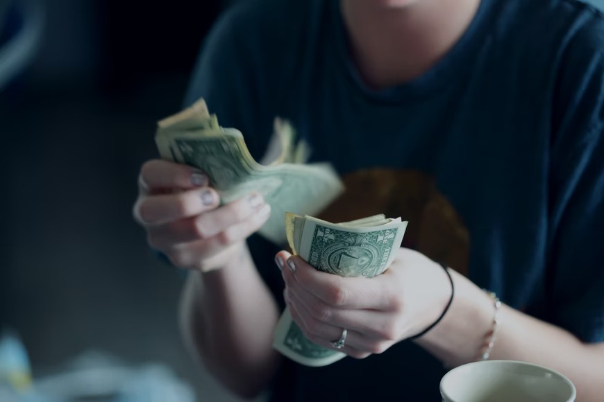 Mujer contando el dinero que tiene en sus manos